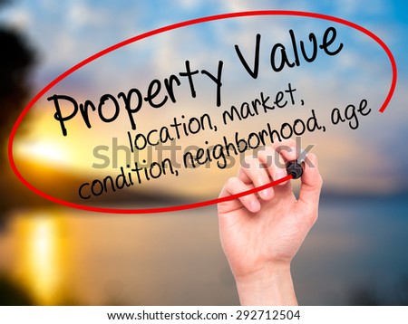Man Hand writing Property Value - location, market, condition, neighborhood, age with black marker on visual screen. Isolated on nature. Business, technology, internet concept. Stock Image
