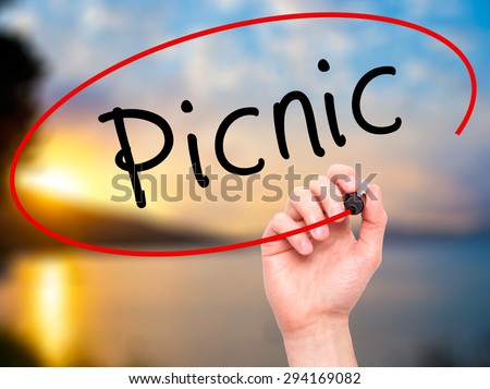 Man Hand writing Picnic with black marker on visual screen. Isolated on nature. Business, technology, internet concept. Stock Photo
