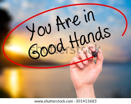 Man Hand writing You Are in Good Hands with black marker on visual screen. Isolated on nature. Business, technology, internet concept. Stock Photo