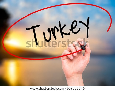Man Hand writing Turkey  with black marker on visual screen. Isolated on nature. Business, technology, internet concept. Stock Photo