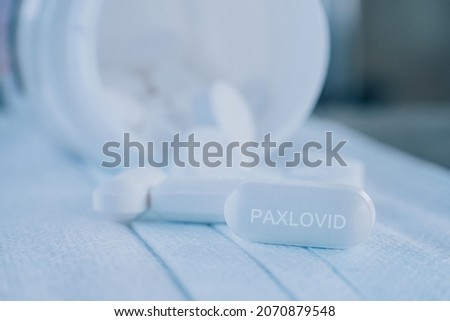 Paxlovid tablet medication for treatment Covid19, potential new drug cure for COVID 19 Corona virus closeup. Therapy for Koronavirus. Pharmaceuticals on mask.