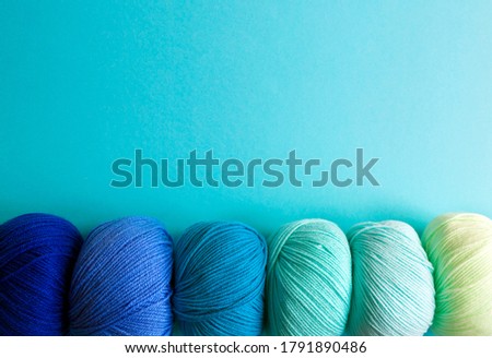 Acrylic balls of yarn on a blue background. Nuance color combination. The skeins are located horizontally at the bottom. Imagine de stoc © 