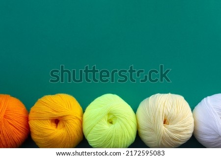 Acrylic balls of yarn on a green background. Nuance color combination. The skeins are located horizontally at the bottom. Imagine de stoc © 