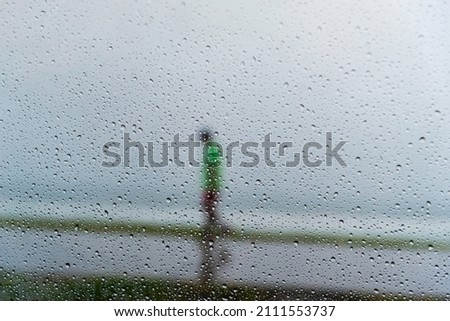 Salvador, Bahia, Brazil - November 15, 2021: A person walking along the waterfront in the middle of the rain. Salvador, Bahia, Brazil.