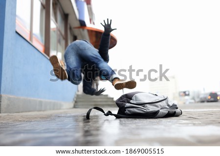Man in winter dress slip on sidewalk with ice closeup background. Heath insurance concept Сток-фото © 
