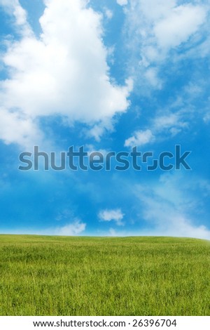 Green hill under blue cloudy sky whit sun