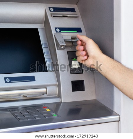 Hand inserting card into cash machine