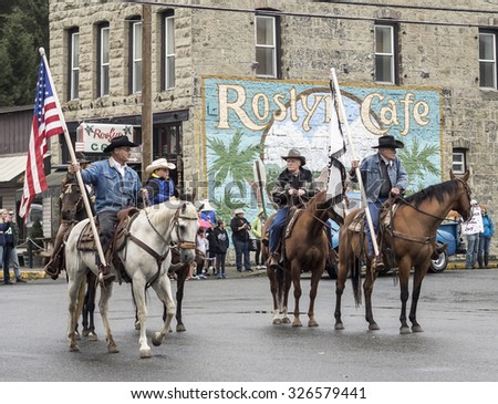 ROSLYN, WA - September 6, 2015: Labor day weekend parade attendees watch cowboys on horseback walk in historic old town main street.