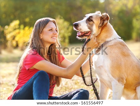 Portrait of a woman and central Asian shepherd in park outdoors