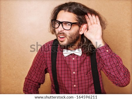 Emotional portrait of a guy who is trying to hear each other, hipster Style, studio shot.
