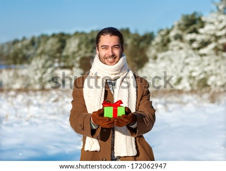 man with gift waiting his woman in the woods in winter the romantic, valentines day concept