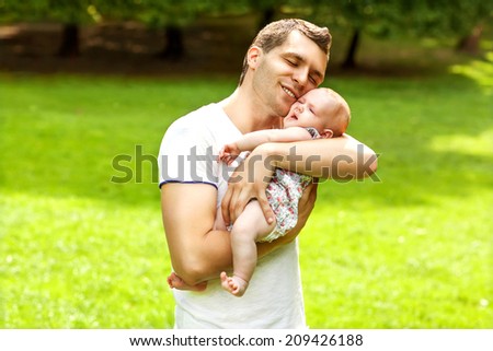 dad and newborn daughter playing in the park in love