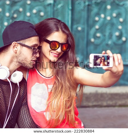 Young fashion couple taking selfie in the city