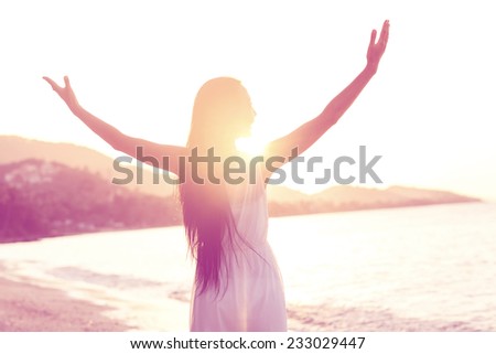 Beautiful girl walking on the beach at sunset, freedom concept
