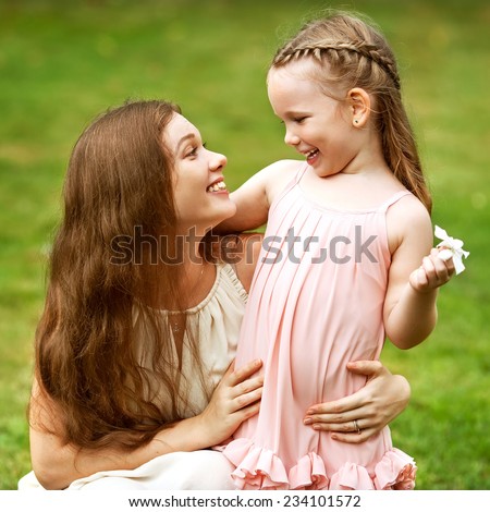 mother and daughter walking in the park holding hands in love