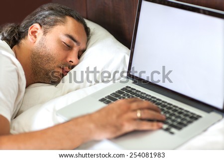 freelancer man with laptop in the morning in his bed emotionally talks at work, free schedule, happy business