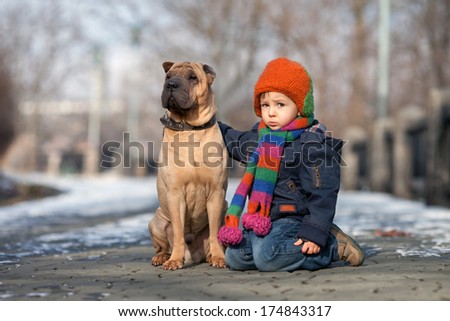 Little boy in the park with his dog friends