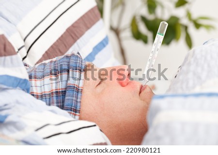 Man with clinical thermometer in his mouth
