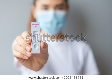 woman holding Rapid Antigen Test kit with Positive result during swab COVID-19 testing. Coronavirus Self nasal or Home test, Lockdown and Home Isolation concept