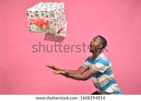 young black man feeling excited while catching gift boxes Stock foto © 