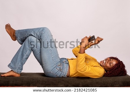 black lady lying on a bench using a phone rejoices ストックフォト © 