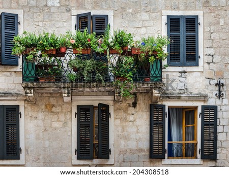 Mediterranean house with shutters and balcony with flowers. Kotor, Montenegro.
