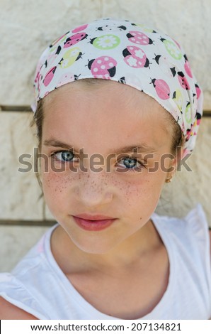 Girl in bandana. Beautiful portrait of a freckled young girl with blue eyes.