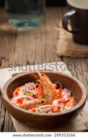 steamed shrimps in a wooden bowl on wood background