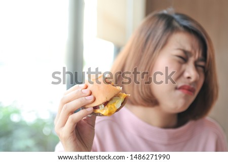 Unpalatable food makes not enjoy eating ,A girl was fulled after eating burger,Burger is hight calories food,Selective focus Stock foto © 