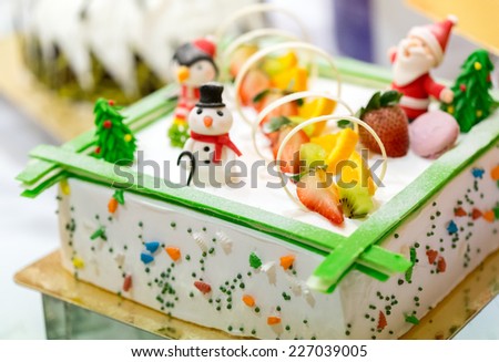 Close up of christmas cake with many fruits and christmas dolls
