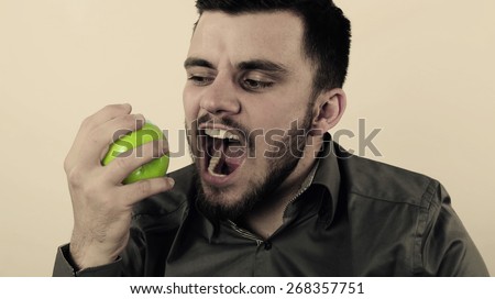 Happy man eating a green apple