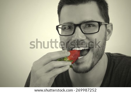 young man eating a strawberry