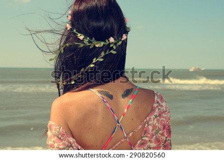 woman with a wreath in her hair looking at the sea