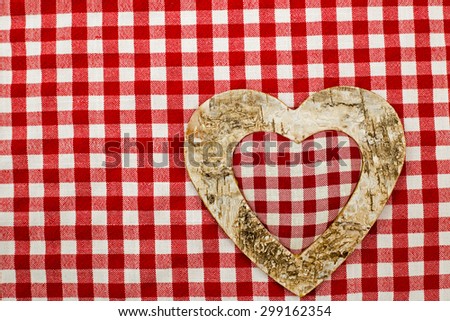 Decorative heart from eco-friendly organic natural birch bark on a white red checkered background