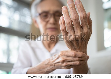 Elderly female patient suffer from numbing pain in hand,numbness fingertip,arthritis inflammation,beriberi or peripheral neuropathies,senior woman massage her hand with wrist pain,rheumatoid arthritis
