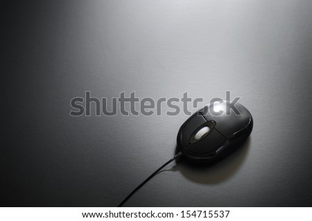 Computer mouse plain black background low light with copy space