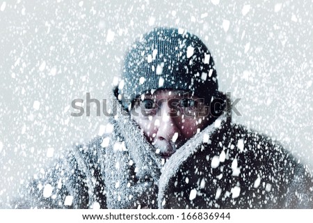 Wintery scene of shivering man in snowstorm or ice storm