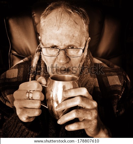 Grumpy old man with mug of tea - sepia.