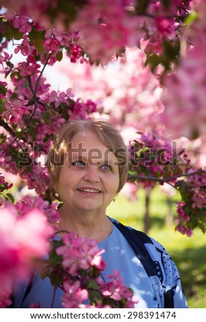 Beauty adult woman under flowering tree in summer