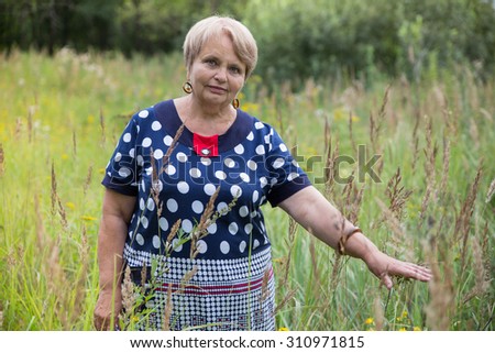 Grandmother walks in the meadow