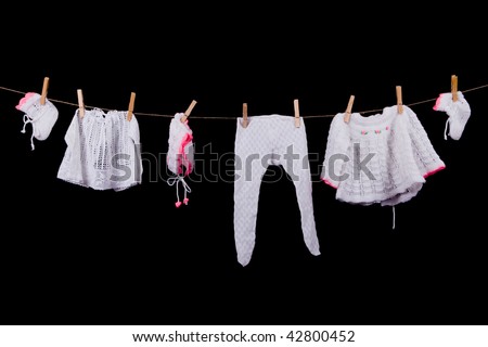 Clean fresh child laundry on a clothing line on black