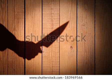Male Hand Shadow with Kitchen Knife, on natural wooden background. You can see more silhouettes and shadows on my page.