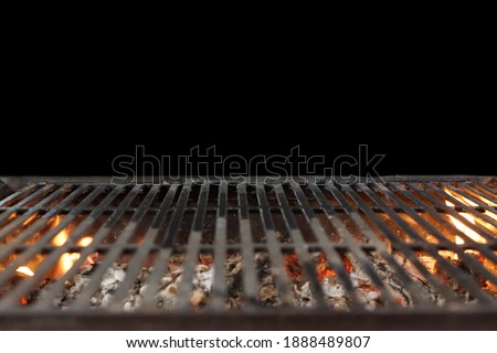 Fire Barbecue Grill Isolated On Black Background. BBQ Flaming Grill Background Isolated. Hot Barbeque Charcoal Cast Iron Grill With Bright Flames In Perspective View.