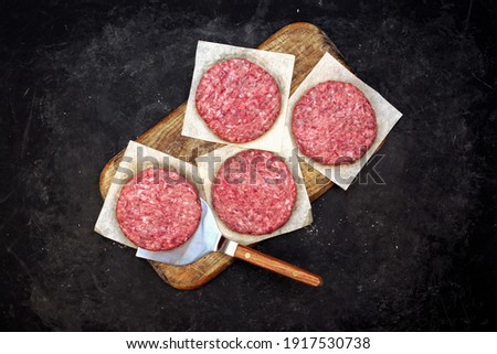 Fresh Raw Minced Homemade Grill Beef Steak Burgers. Raw BBQ Beef Burger Cutlets On Wooden Board, Overhead View. Raw Ground Beef Pork Meat Burger Cutlets For Grilling Or Frying. Raw Hamburger Patty.