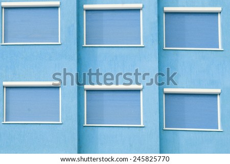 Blue Building Facade with Six Closed Windows Shutters Background with Space for Text or Image
