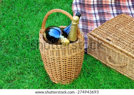 Basket With Champagne Wine,  Hamper And Blanket On Spring Emerald Color Lawn,Summer Picnic Scene Concept