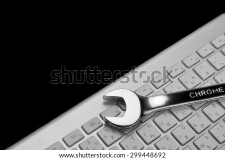 Wrenches With Sign Chrome And  Wireless Keyboard Isolated On Black  Background. Remote Assistance Or Technical Support Or Repair Service Or Bug Fix  Or Business Solutions Concept