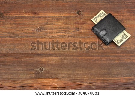 High Angle View Of Modern Black leather Men\'s Wallet With Dollar Cash On The Old Rough Wood Textured Background With Copy Space