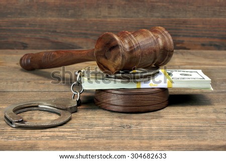 USA Dollar Money Cash, Real Handcuffs And Judge Gavel On Rough Wood Background. Concept For Arrest, Corruption, Bail, Crime, Bribing or Fraud.