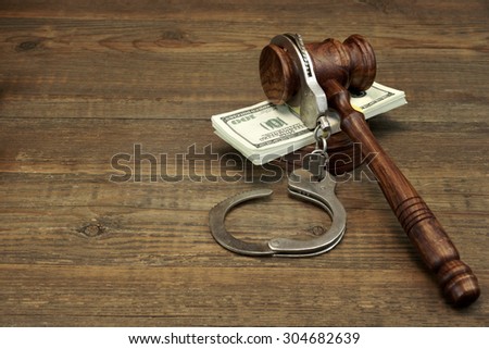 Dollars Cash, Real Handcuffs And Judge Gavel On Rough Wood Background. Concept For Arrest, Corruption, Bail, Crime, Bribing or Fraud.